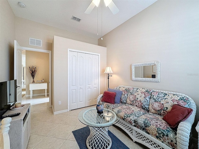 living area featuring lofted ceiling, ceiling fan, light tile patterned flooring, and visible vents