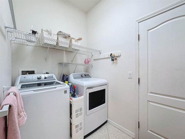 laundry room featuring laundry area, light tile patterned floors, baseboards, and separate washer and dryer