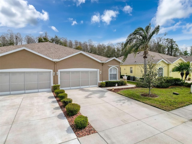 single story home with an attached garage, concrete driveway, a front yard, and stucco siding