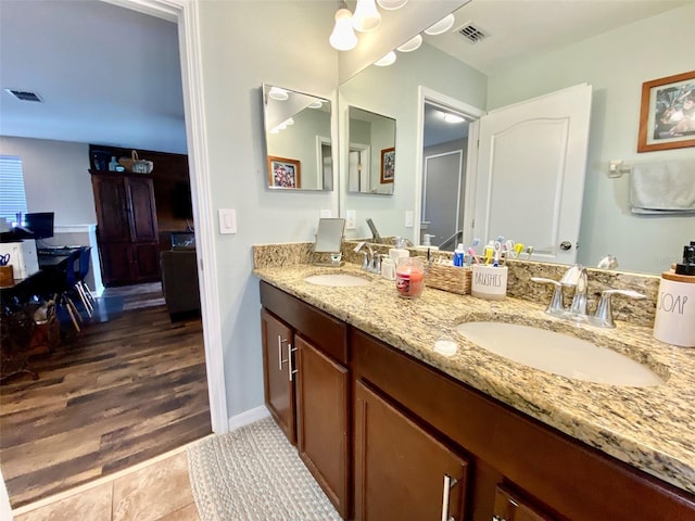 bathroom featuring double vanity, visible vents, and a sink