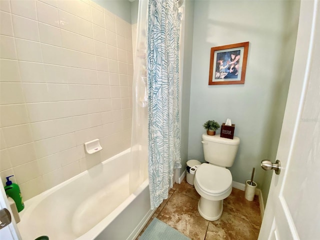 bathroom featuring toilet, baseboards, and shower / bath combo with shower curtain