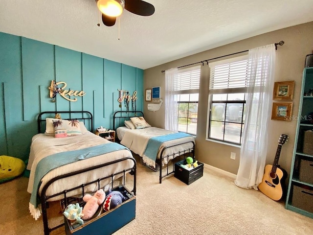 bedroom with carpet, a ceiling fan, and a textured ceiling