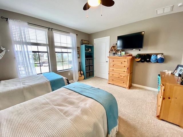 bedroom featuring light carpet, ceiling fan, visible vents, and baseboards