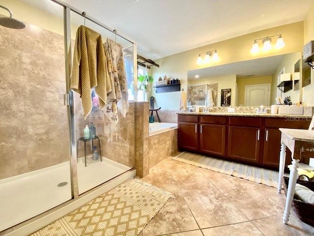 full bathroom with tile patterned floors, a garden tub, vanity, and a shower stall