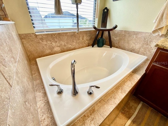 bathroom featuring a garden tub and vanity