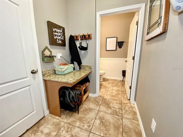 bathroom with wainscoting, vanity, toilet, and tile patterned floors