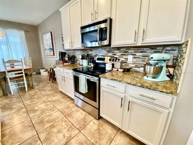 kitchen with light tile patterned floors, stone countertops, decorative backsplash, stainless steel appliances, and white cabinetry