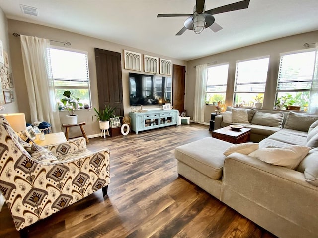 living room with plenty of natural light, visible vents, dark wood finished floors, and baseboards