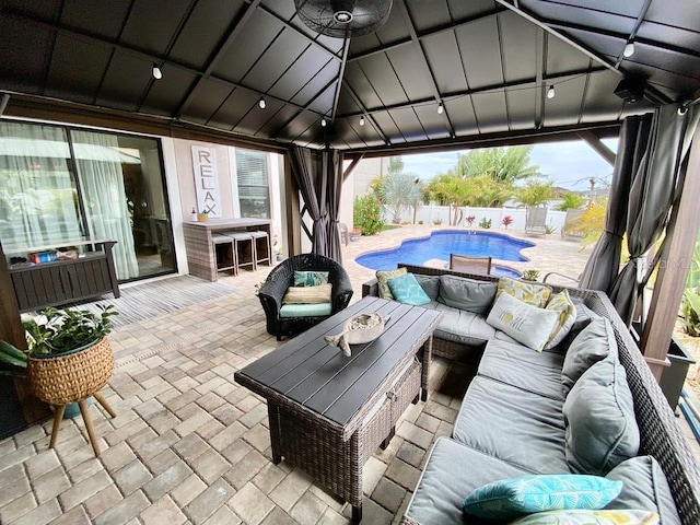 view of patio featuring fence, outdoor lounge area, a fenced in pool, and a gazebo