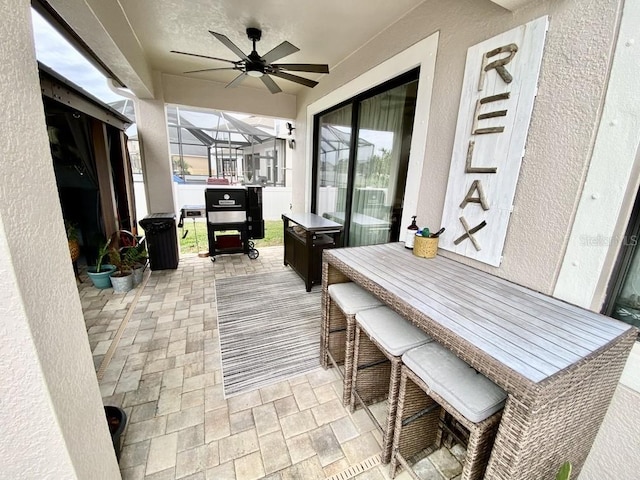 view of patio / terrace featuring glass enclosure and ceiling fan