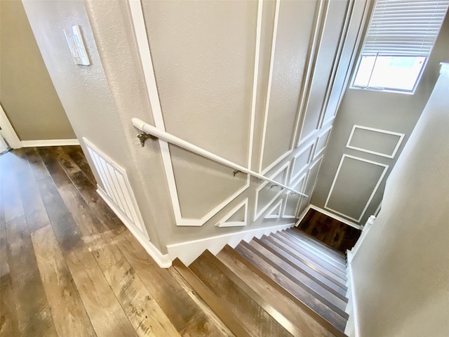 stairway with hardwood / wood-style flooring and baseboards