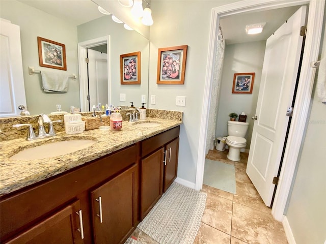 bathroom featuring double vanity, tile patterned flooring, a sink, and toilet