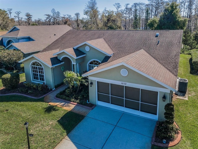 view of front of house featuring roof with shingles, stucco siding, concrete driveway, a garage, and a front lawn