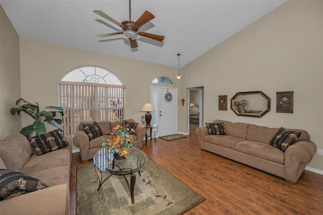 living area with lofted ceiling, ceiling fan, baseboards, and wood finished floors