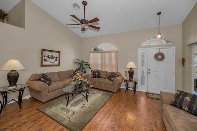 living area with a ceiling fan, visible vents, baseboards, and wood finished floors