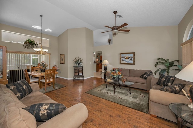 living room featuring baseboards, visible vents, wood finished floors, high vaulted ceiling, and ceiling fan with notable chandelier