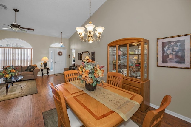 dining room featuring high vaulted ceiling, ceiling fan with notable chandelier, baseboards, and wood finished floors