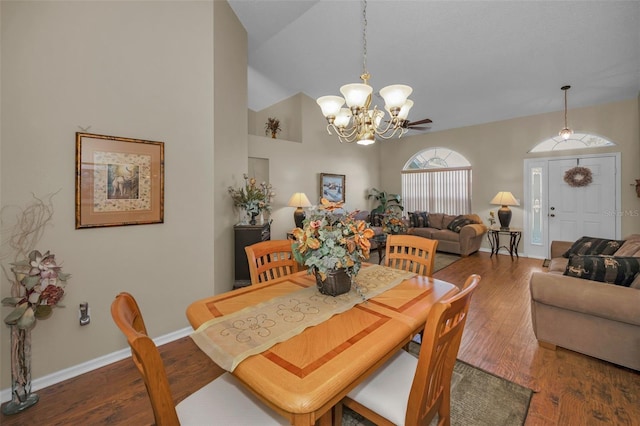 dining room with baseboards, high vaulted ceiling, wood finished floors, and an inviting chandelier