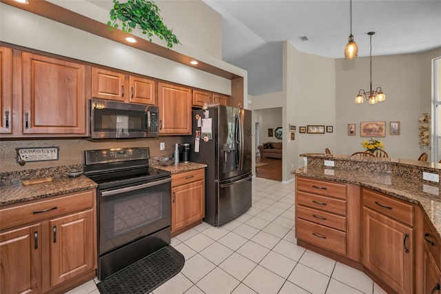 kitchen featuring light tile patterned floors, a chandelier, brown cabinets, black appliances, and pendant lighting