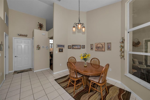 dining room featuring high vaulted ceiling, visible vents, baseboards, and light tile patterned floors