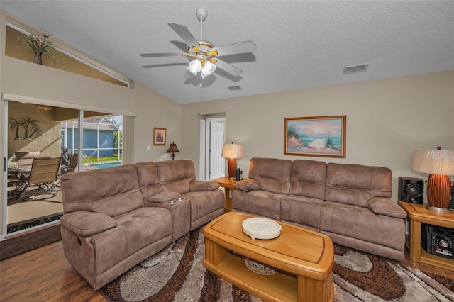 living room with lofted ceiling, visible vents, a textured ceiling, and wood finished floors