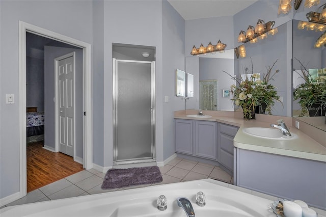 full bath featuring double vanity, a shower stall, a sink, and tile patterned floors