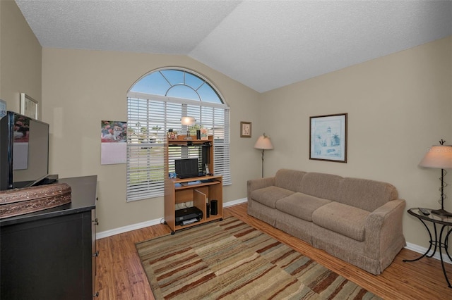 living room featuring vaulted ceiling, a textured ceiling, baseboards, and wood finished floors