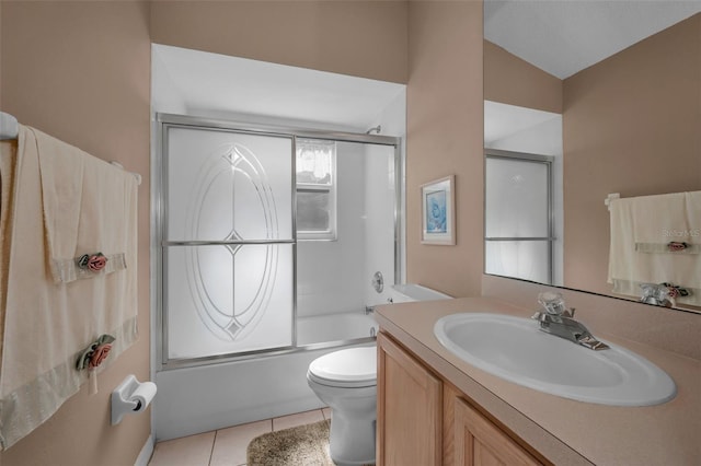 full bath featuring vanity, combined bath / shower with glass door, tile patterned flooring, and toilet