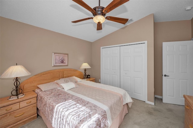 bedroom featuring light carpet, visible vents, lofted ceiling, ceiling fan, and a closet