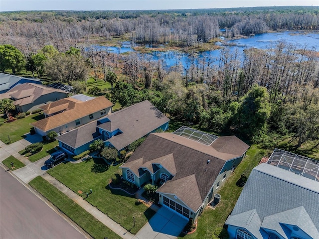 drone / aerial view with a water view and a forest view