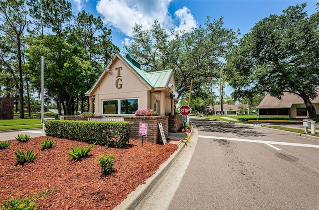 view of front of home with metal roof, a standing seam roof, and stucco siding