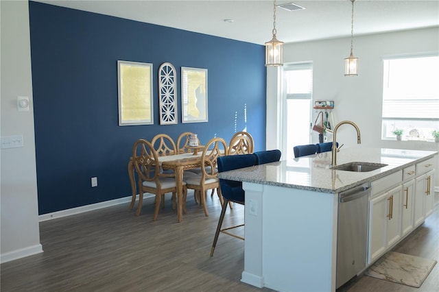 kitchen featuring dark wood finished floors, dishwasher, a breakfast bar, white cabinetry, and a sink