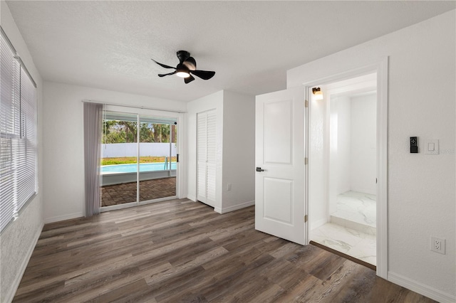 unfurnished room featuring a textured ceiling, ceiling fan, wood finished floors, and baseboards