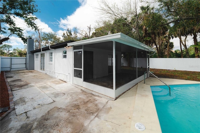 view of pool featuring a sunroom, fence, and a patio