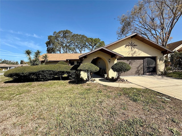 ranch-style home with a garage, a front yard, concrete driveway, and stucco siding