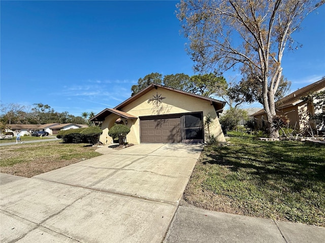 view of front of home with an attached garage, driveway, a front yard, and stucco siding