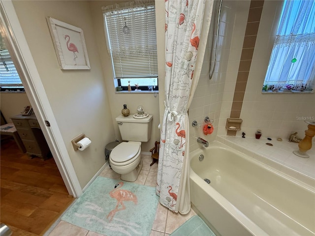 full bath with toilet, tile patterned flooring, baseboards, and shower / tub combo with curtain