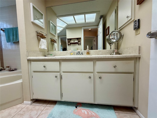 bathroom with a washtub, vanity, and tile patterned floors