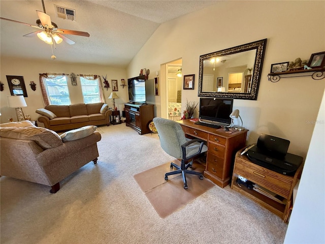 office space featuring visible vents, light colored carpet, ceiling fan, vaulted ceiling, and a textured ceiling