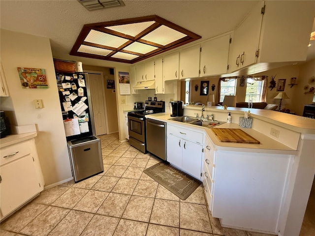 kitchen featuring under cabinet range hood, stainless steel appliances, a peninsula, a sink, and visible vents