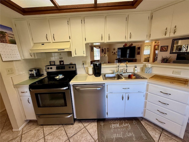 kitchen featuring appliances with stainless steel finishes, light countertops, a sink, and under cabinet range hood