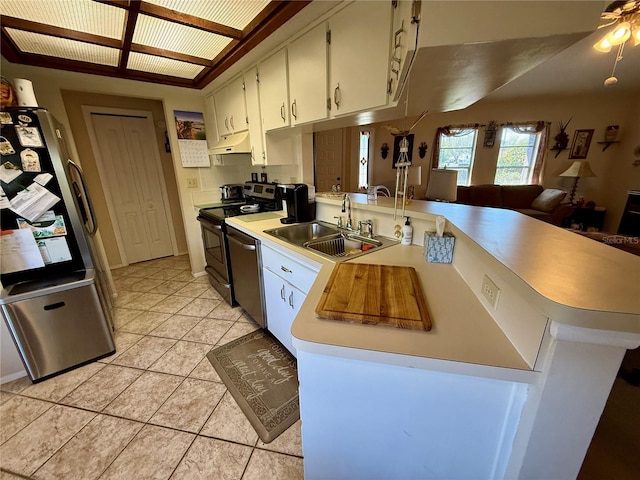 kitchen with under cabinet range hood, a peninsula, a sink, light countertops, and appliances with stainless steel finishes