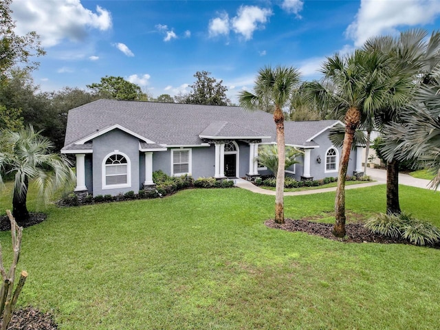 view of front of home with driveway, a front lawn, an attached garage, and stucco siding