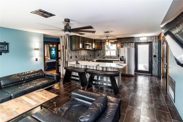 living room featuring visible vents and a ceiling fan