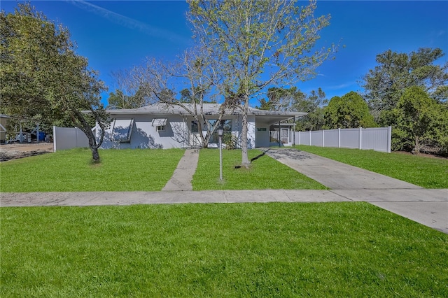 single story home with an attached carport, concrete driveway, fence, and a front lawn