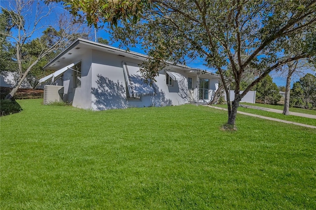 view of front of house featuring a front lawn and stucco siding