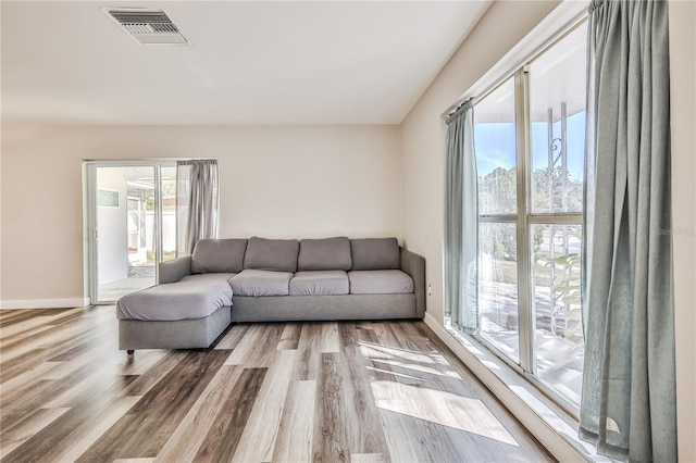 living area with visible vents, baseboards, and wood finished floors