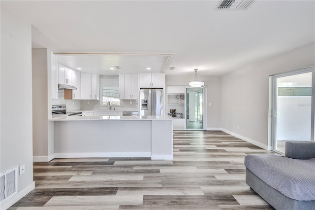 kitchen with open floor plan, appliances with stainless steel finishes, visible vents, and under cabinet range hood