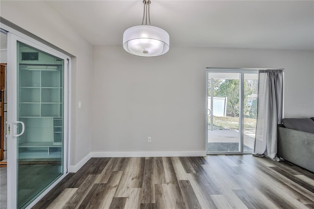 unfurnished room featuring baseboards and wood finished floors