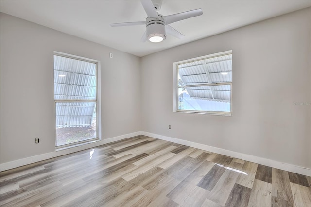 empty room featuring a ceiling fan, baseboards, and wood finished floors